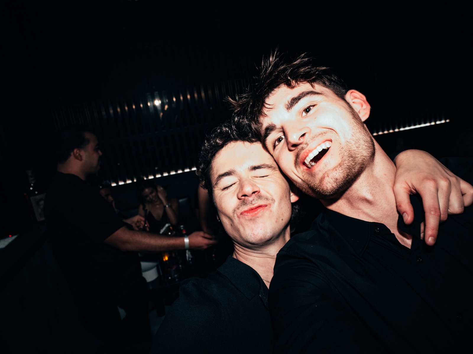 Twee feestende gasten die lachen en poseren tijdens CB Nights, met een gezellige en spontane sfeer.