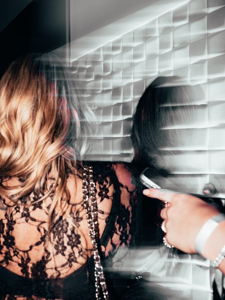 Vrouw in zwarte kanten jurk met motion blur tijdens event.