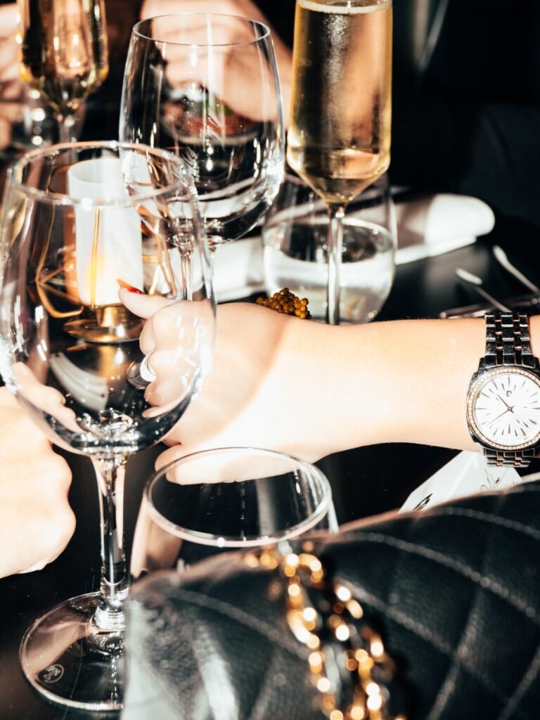 Luxe tafelsetting met champagneglazen en hand met horloge.
